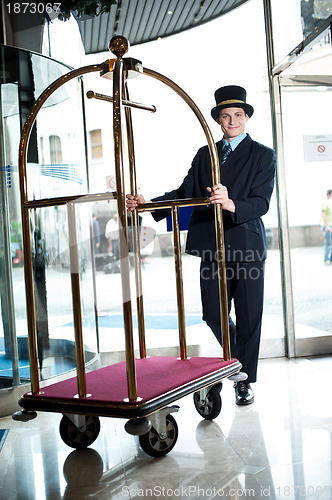 Image of Profile shot of a doorman holding a cart