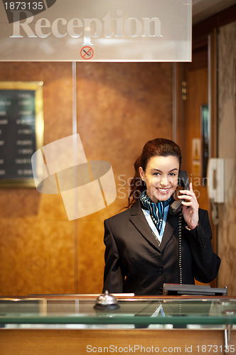 Image of Attractive young receptionist receiving calls