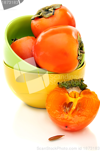 Image of Three whole juicy persimmon and half.