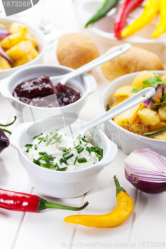 Image of Sour cream and chutney with baked potatoes