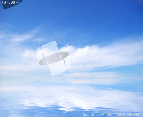 Image of white fluffy clouds with rainbow in the blue sky