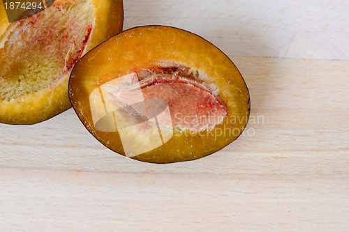 Image of Plum with a slice and leaf on a natural light.