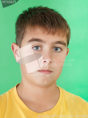 Image of studio portrait of young boy on green background