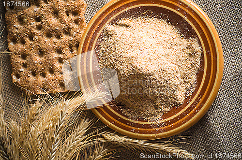 Image of Wholemeal flour and wheat on cloth sack, close-up