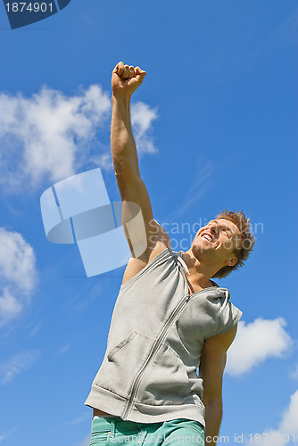 Image of Smiling young man with his arm raised in joy