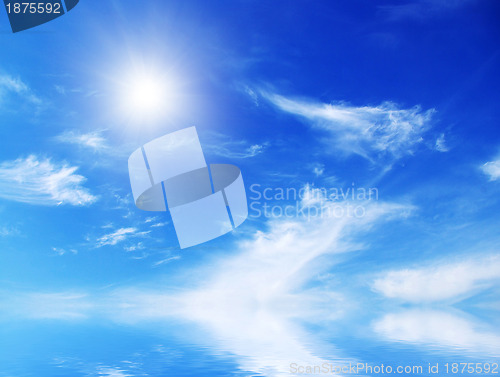 Image of white fluffy clouds with rainbow in the blue sky