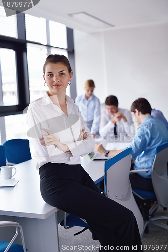 Image of business woman with her staff in background at office