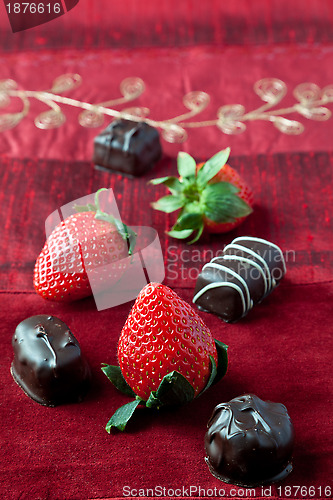 Image of Strawberries and Chocolates on Red Background