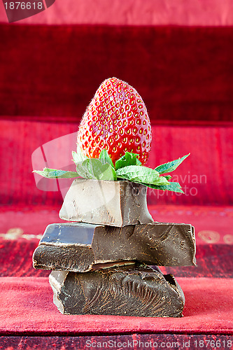 Image of Strawberry Balancing on a Pile of Dark Chocolate