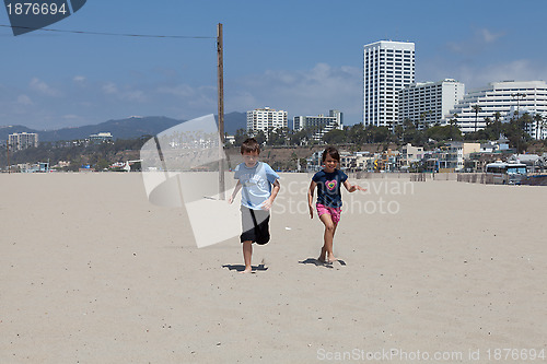 Image of Girl and Boy Running on the Beach
