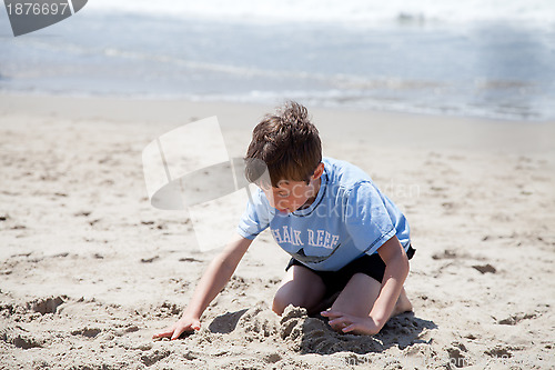 Image of Little Boy Playing with sand on the Beach