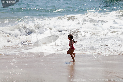 Image of Little Girl Running in the Surf on the Beach