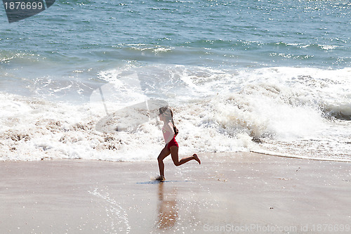 Image of Little Girl Running in the Surf on the Beach