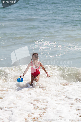 Image of Little Girl Playing with a Bucket on the Beach