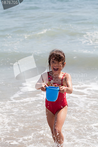 Image of Little Girl Playing with a Bucket on the Beach