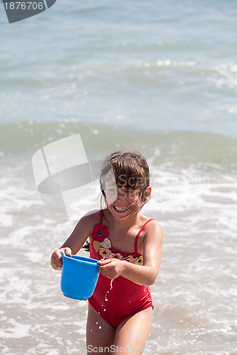 Image of Little Girl Playing with a Bucket on the Beach