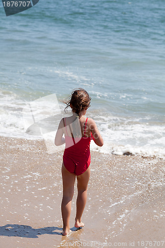 Image of Little Girl Walking into the Ocean Surf on the Beach