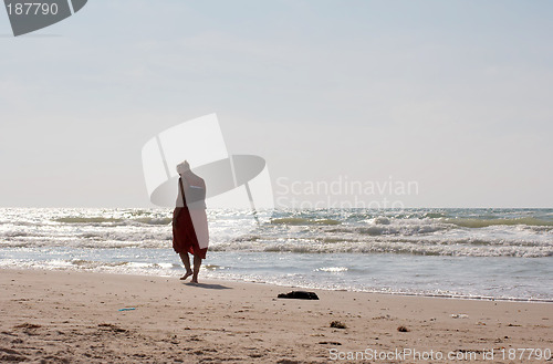 Image of A woman walking on the beach.