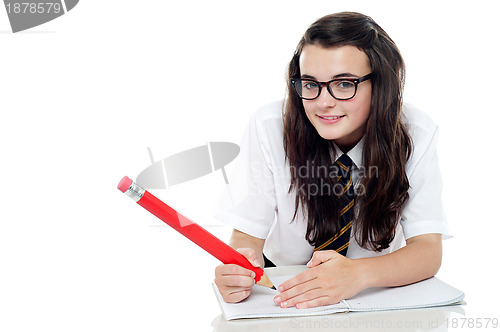 Image of Bespectacled schoolgirl with long hair studying