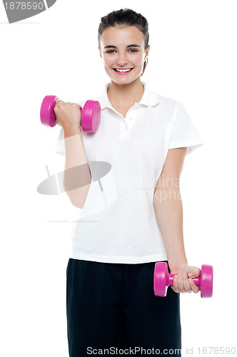 Image of Smiling fitness teenage girl lifting weights