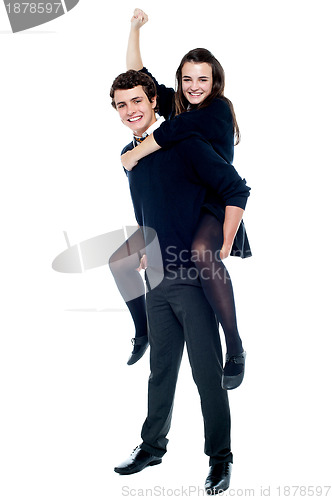 Image of Schoolgirl cheering with raised arm during piggy ride