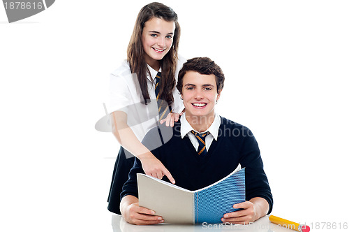 Image of Girl pointing out the answer to her classmate