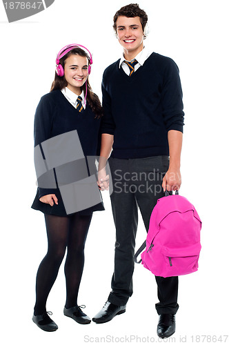 Image of Boy holding pink backpack posing with female student