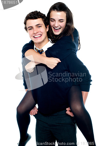 Image of Cheerful boy carrying school friend on his back