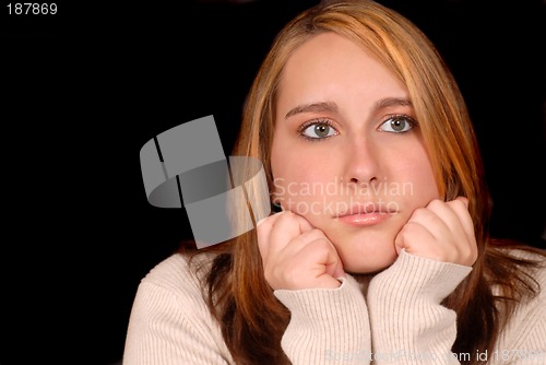Image of Young woman posing with her hands on her chin