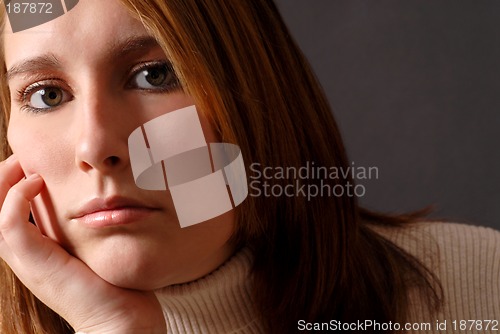 Image of Closeup of an attractive young woman with her chin resting on he