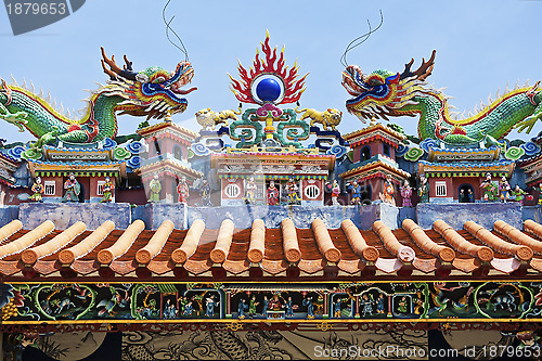 Image of Dragon statues in Chinese style on top of temple roof 