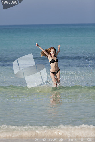 Image of Woman with bikini in the sea jumping portrait