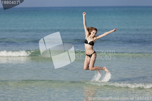 Image of Woman with bikini jumping in the sea landscape