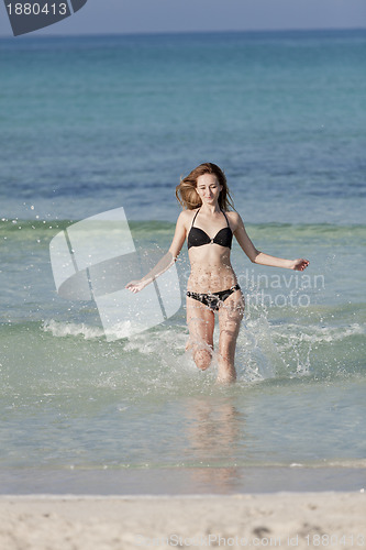 Image of Woman with bikini in the sea jumping portrait