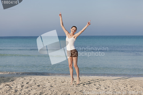 Image of Woman cherfull jumping on beach landscape