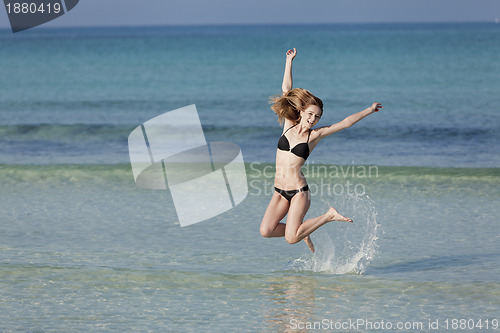 Image of Woman with bikini jumping in the sea landscape