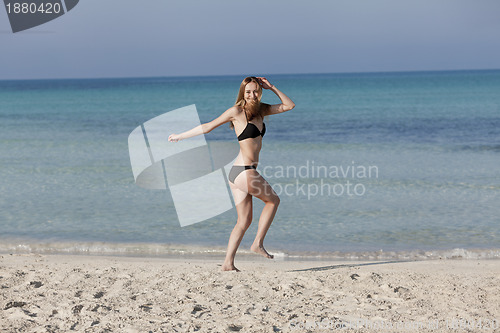 Image of Woman with bikini in the sea jumping landscape