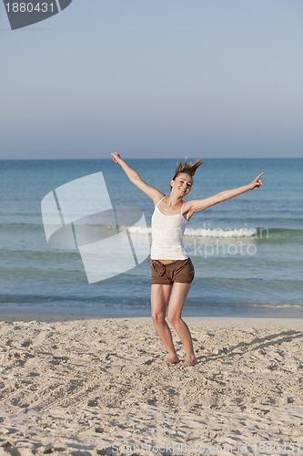 Image of Cheerful woman jumping laughing at beach portrait