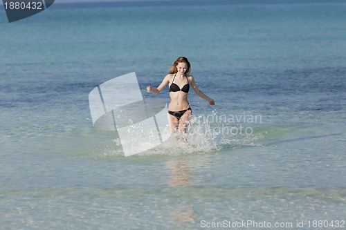 Image of Woman with bikini in the sea jumping landscape