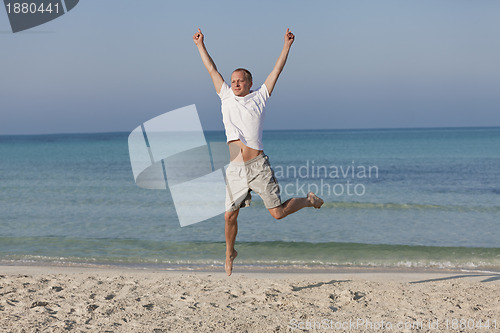 Image of Cheerful man jumping on the beach laughing Landscape