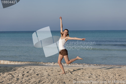 Image of Woman cherfull jumping on beach landscape