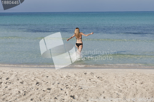 Image of Woman with bikini in the sea jumping landscape