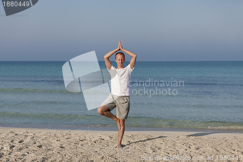 Image of Man making yoga on the beach Sports Landscape