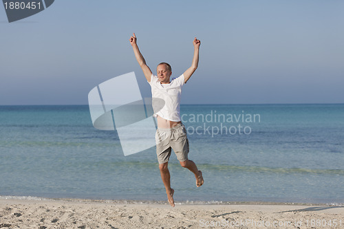 Image of Cheerful man jumping on the beach laughing Landscape