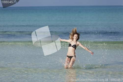 Image of Woman with bikini jumping in the sea landscape