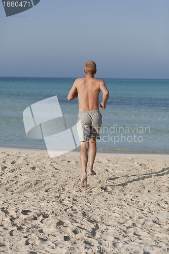 Image of man running on the beach in water portrait