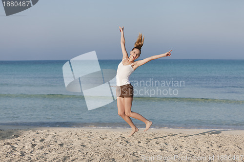 Image of Woman cherfull jumping on beach landscape