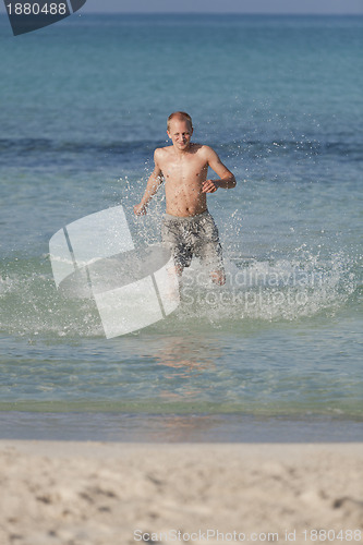 Image of man running on the beach in water portrait