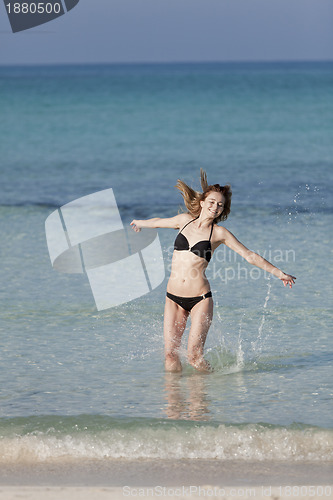 Image of Woman with bikini jumping in the sea hochformat