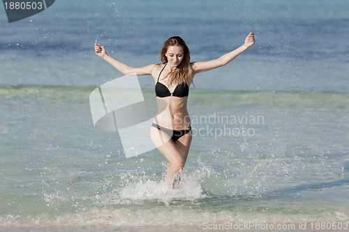 Image of Woman with bikini in the sea jumping landscape